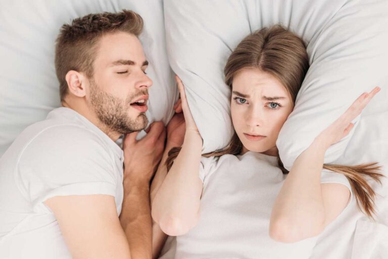 top-view-of-woman-plugging-ears-with-pillow-while-2023-11-27-05-22-13-utc